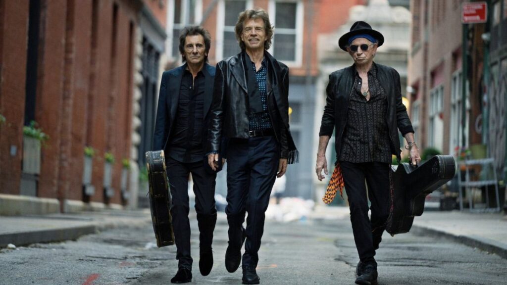 Ronnie Wood, Mick Jagger and Keith Richards walking, dressed in black 